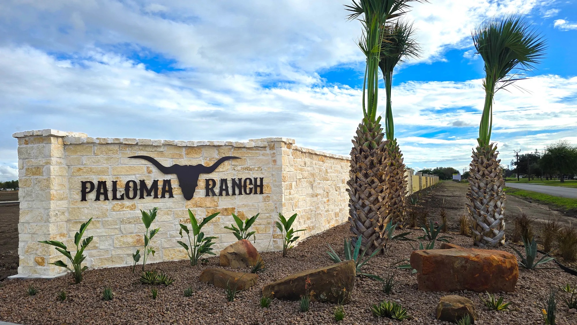 Paloma Ranch community entrance with stone monument and palm trees